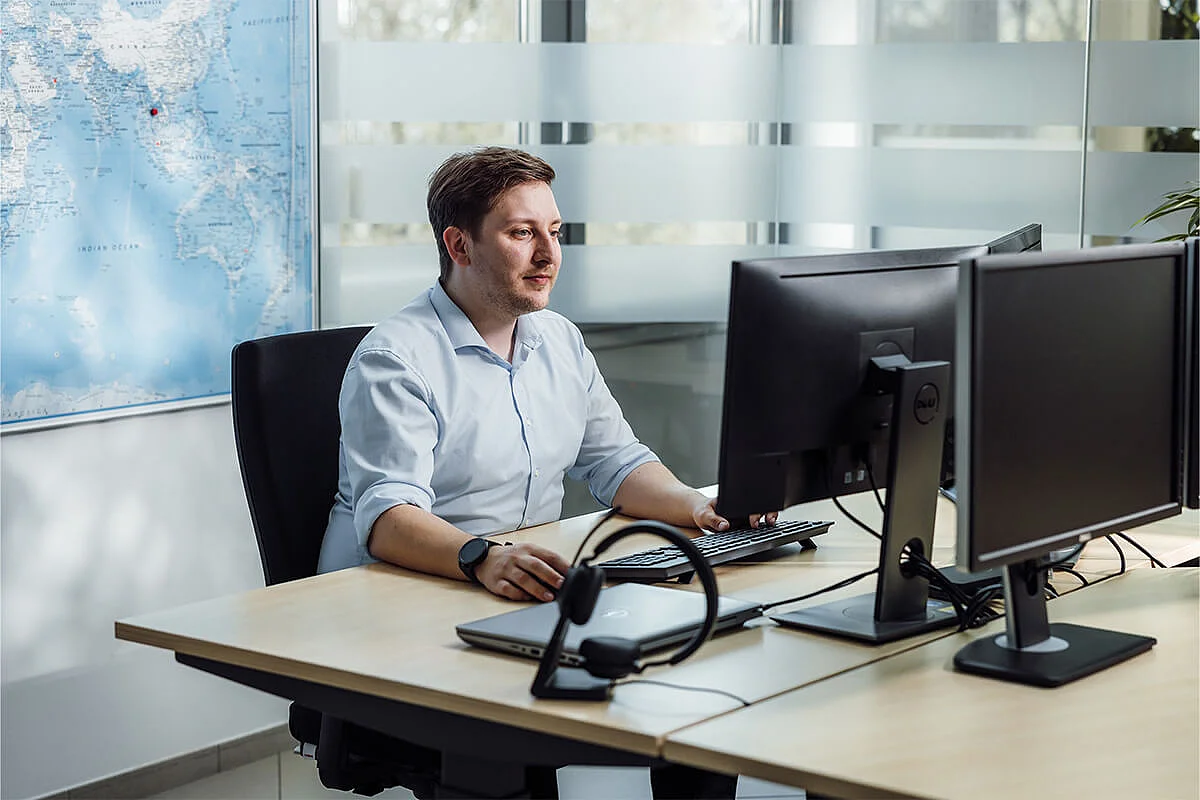 A SOMIC employee is sitting at a computer and processing a customer order - Customer Service